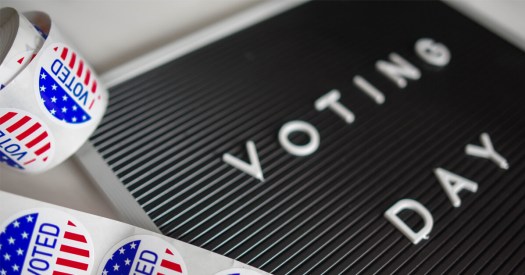 Word Board Reads "Voting Day," "I Voted" Stickers Next to Sign